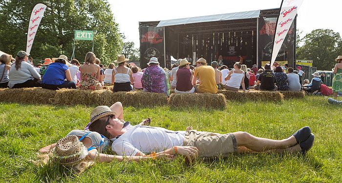 Chilled-out festival goers enjoying the entertainment on the Riverside Stage.